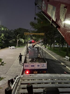 a truck with a crane on the back and a man standing next to it